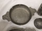 a lot of old pots and pans sitting on a table