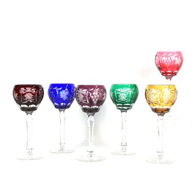 six verres à vin sont alignés sur une surface blanche