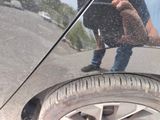 a reflection of a man in a mirror on the side of a car