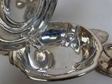a silver plate with a lid on a white table