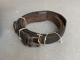 a brown leather belt and a brown leather belt on a table