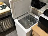 a small refrigerator in a small kitchen with a microwave on top of it
