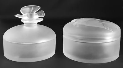 two clear plastic containers with lids on a black surface