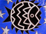 a blue and black plate with a fish design on it