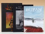 Trois livres sont posés sur une surface blanche avec un fond marron.