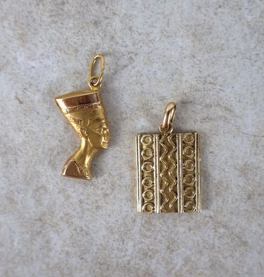 un pendentif plaqué or représentant une tête égyptienne et un coffret plaqué or