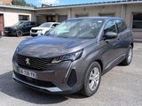 La voiture grise est garée sur le parking, à côté d'autres voitures.