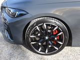 the front end of a gray bmw car parked in a parking lot