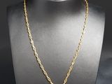 a gold necklace with a cross charm on a mannequin neck
