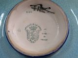 a blue and white plate with a picture of a coat of arms on it