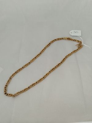 a close up of a gold chain on a white surface