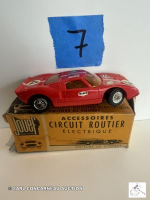 une petite voiture rouge posée sur une boîte en carton