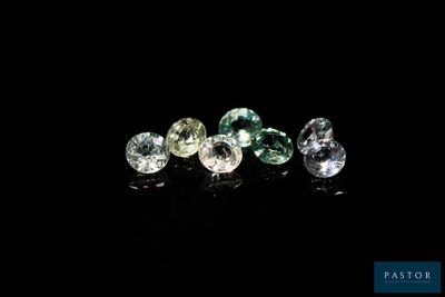 un ensemble de trois diamants de couleurs différentes sur une surface noire