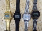 three watches are sitting next to each other on a woven surface