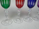 four wine glasses are lined up in a row on a table