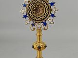 une image représentant une horloge dorée et bleue posée sur un socle