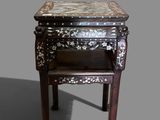 a small table with a marble top on a gray background