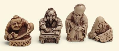 trois figurines représentant des personnes assises sur une table, sur fond blanc