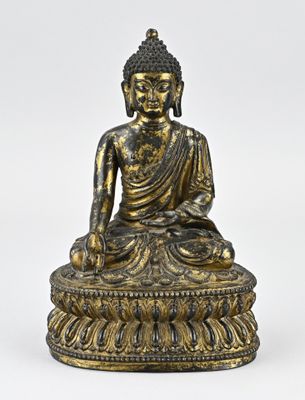 une statue en bronze représentant une personne assise sur un lotus