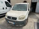 une camionnette blanche sale garée devant un immeuble