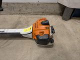 a chainsaw sitting on the floor next to a trash can