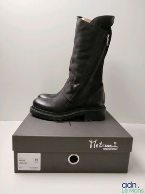 black leather boots with zippers are on top of a box