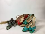 several pairs of women ' s shoes and a basket on a white surface