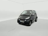 La petite voiture noire est garée dans une pièce blanche.