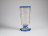 a glass vase with a blue rim sitting on a white surface