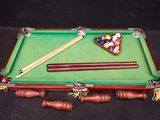 a pool table with a billiards rack and cues on it