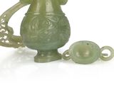 a green vase with a handle next to a green teapot