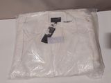 un t-shirt blanc emballé dans du plastique, posé sur une table