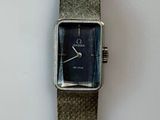 une montre-bracelet en argent avec un cadran bleu sur un fond blanc