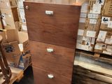 a tall wooden filing cabinet in the middle of a pile of boxes