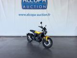 a yellow motorcycle parked in front of a white wall
