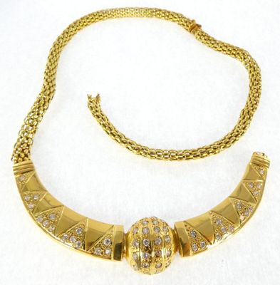 a close up of a necklace on a white surface with a chain