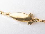 an image of a close up of a gold necklace on a white surface
