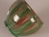 a green and red vase sitting on a white surface