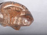 a wooden sculpture of a fish on a white surface