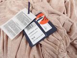 a label on a piece of clothing that is on a bed