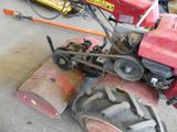 a small red tractor that is parked in a garage