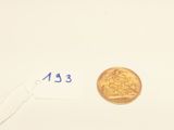 a gold coin on a white surface with a price tag on it