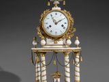 a white and gold clock sitting on top of a table