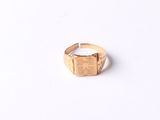 gros plan d'une bague en or sur une surface blanche