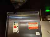 an image of a stainless steel refrigerator in a dark room