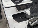 une imprimante blanche posée sur une imprimante noir et blanc