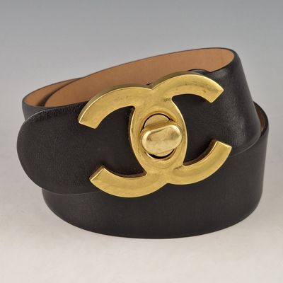 un gros plan sur une ceinture noire et dorée dotée d'une boucle dorée