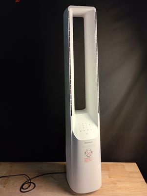 a white tower fan sitting on top of a wooden table
