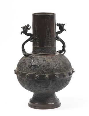 un vase en bronze surmonté de deux oiseaux