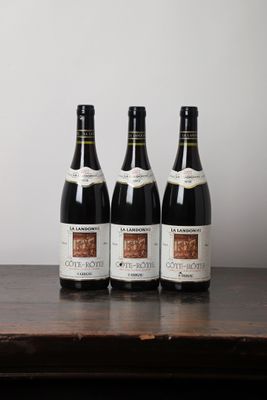 trois bouteilles de vin posées sur une table en bois